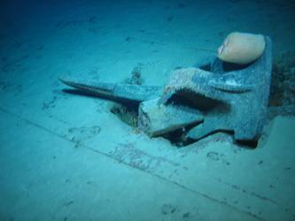 Stbd anchor embedded in steel plate from ship's side in debris field